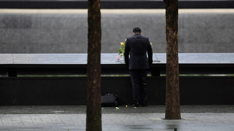 A person leaves flowers at the 9/11 memorial's north pool...