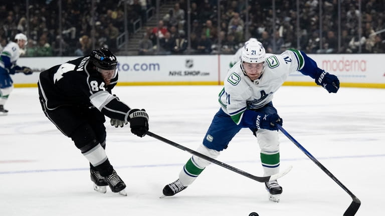 Vancouver Canucks left wing Nils Hoglander (21) and Los Angeles...