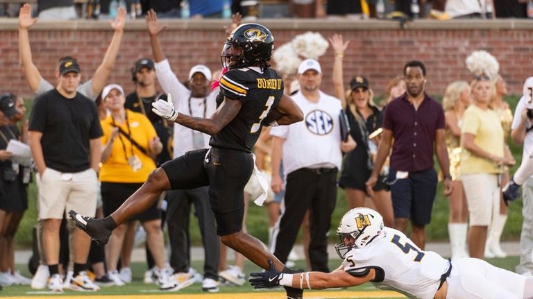 Missouri wide receiver Luther Burden III, left, dances into the...