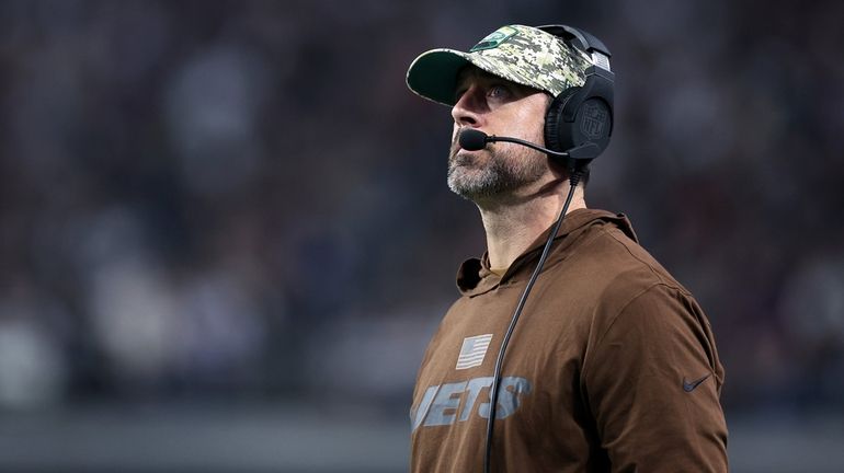 Jets quarterback Aaron Rodgers of the Jets watches from the sidelines...