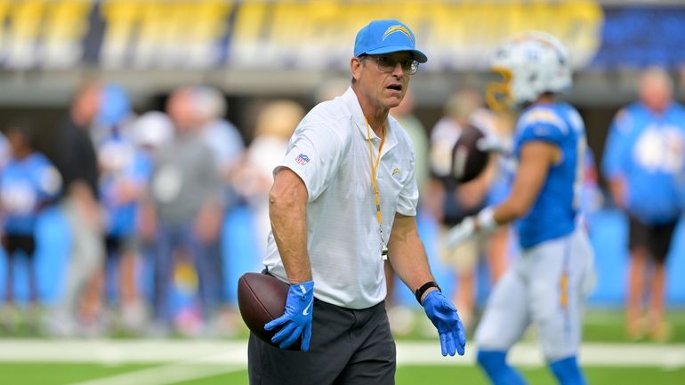 Los Angeles Chargers head coach Jim Harbaugh prepares to throw...