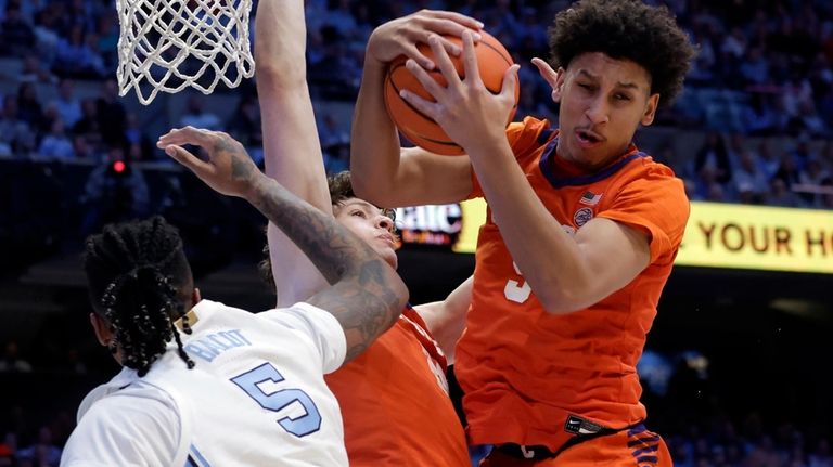 Clemson forward Jack Clark, right, grabs a rebound next to...