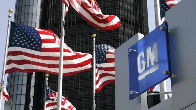 Flags fly outside the Detroit headquarters of General Motors on...