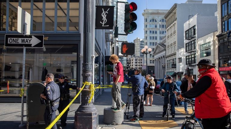 Police officers secure the area and investigate the scene of...