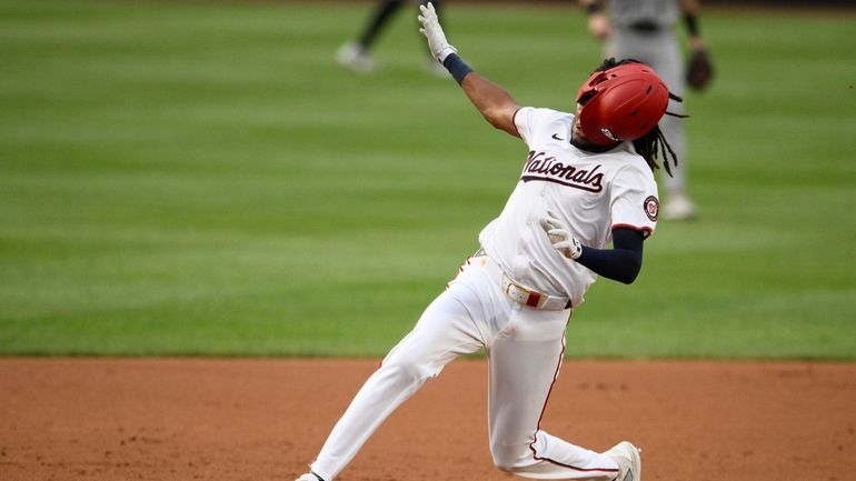 Washington Nationals' James Wood runs towards third with a triple...