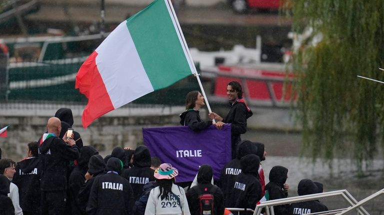 Athletes of Italy travel by boat along the Seine river...