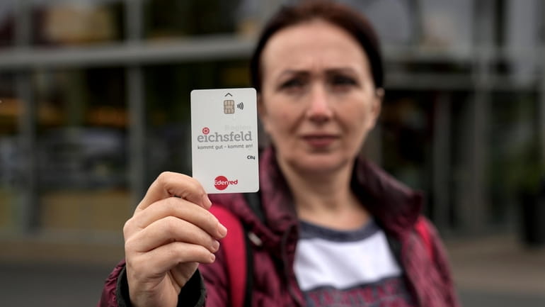 Erdina Laca, a 45-year-old asylum seeker, shows her special payment...
