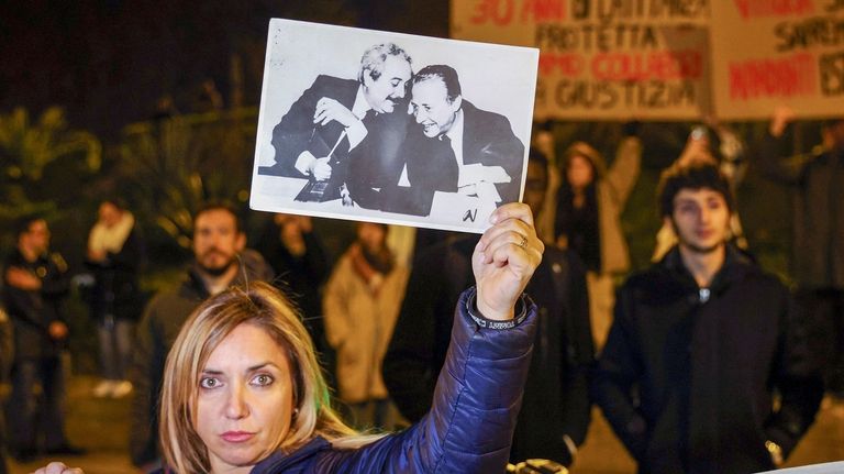 A woman displays a photograph that became iconic in Italy...