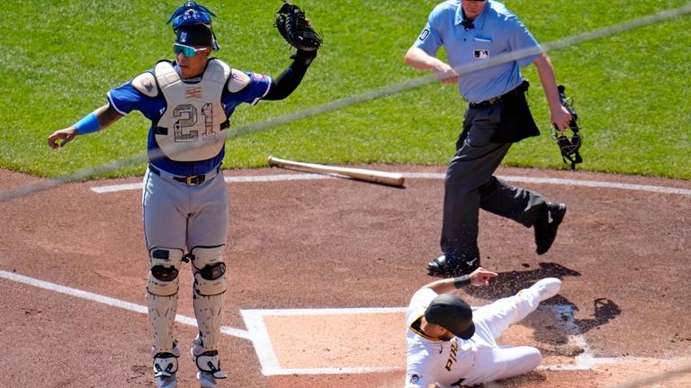 Pittsburgh Pirates' Isiah Kiner-Falefa, lower right, scores on a double...