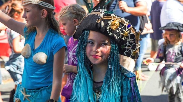 Mermaids and pirates make their way down Front Street during...