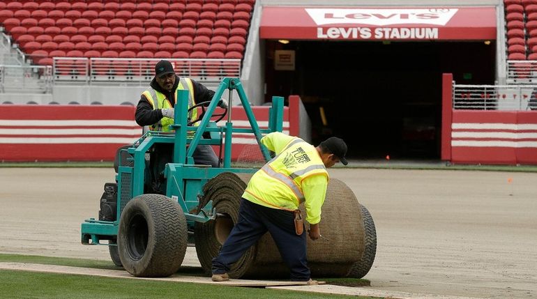 Workers install sod on the field at Levi's Stadium in...