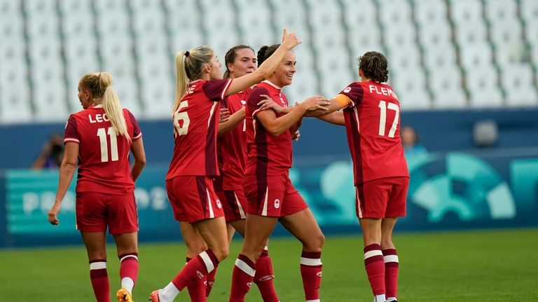 Canada's Evelyne Viens, 2nd right, celebrates with teammates after scoring...