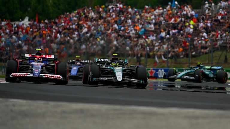 Mercedes driver Lewis Hamilton of Britain, center, steers his car...