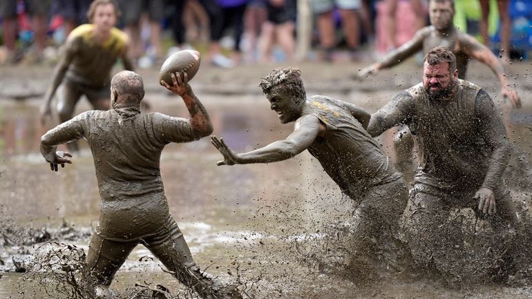 The Mudshark's Jevin Smith, center, gets around Muddas' blocker Kurt...