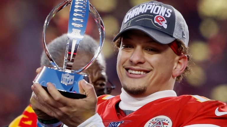 The Chiefs' Patrick Mahomes holds up the Lamar Hunt Trophy...