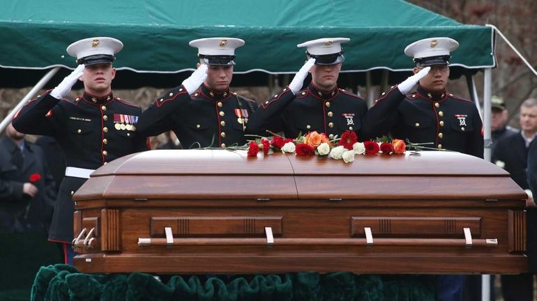 Marines salute the coffin of 19-year-old Marine Nicholas Buscarnera during...