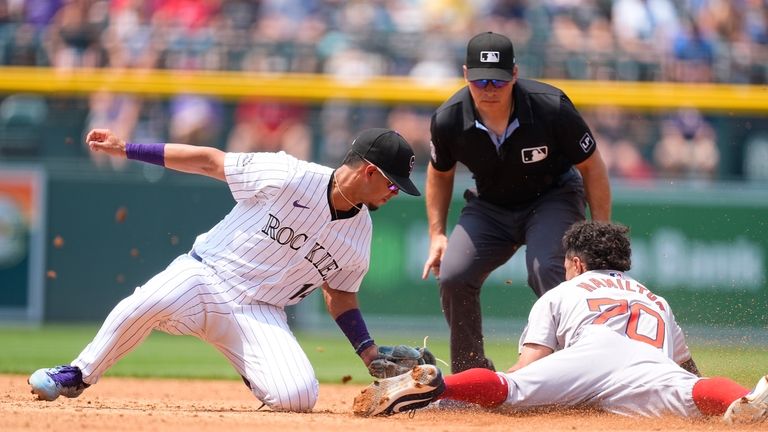 Colorado Rockies shortstop Ezequiel Tovar, left, tags out Boston Red...