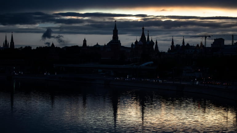 The Kremlin, left, and St. Basil Cathedral, center right, are...