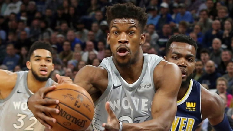 Jimmy Butler drives as the Nuggets' Paul Millsap defends during...