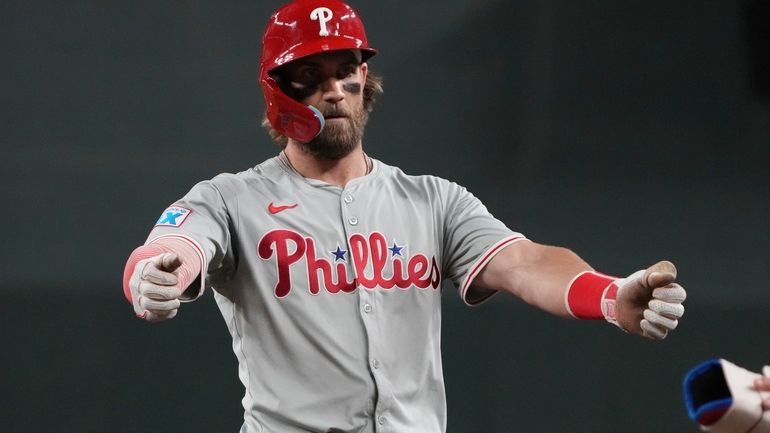 Philadelphia Phillies' Bryce Harper reacts after hitting an RBI single...