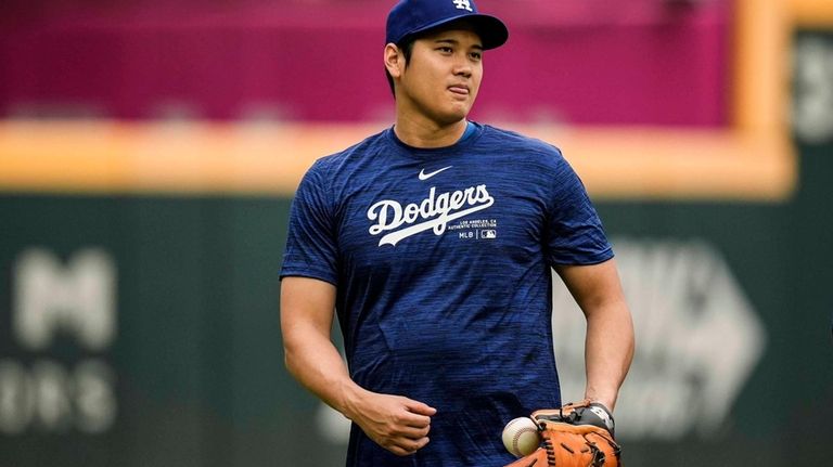 Los Angeles Dodgers' Shohei Ohtani warms up before a baseball...