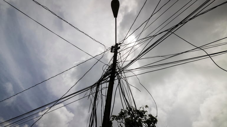 A utility pole with loose cables towers over a home...