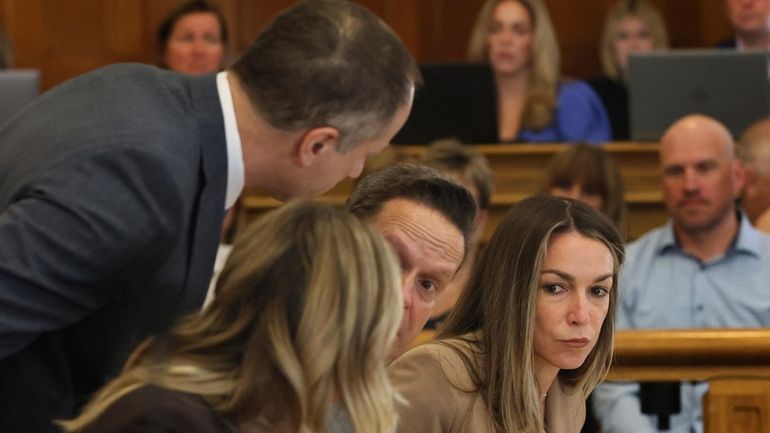 Karen Read sits at the defense table with her attorneys...