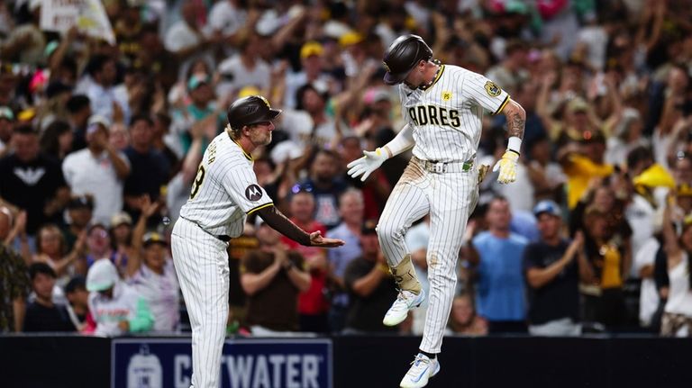 San Diego Padres' Jackson Merrill, right, celebrates with third base...