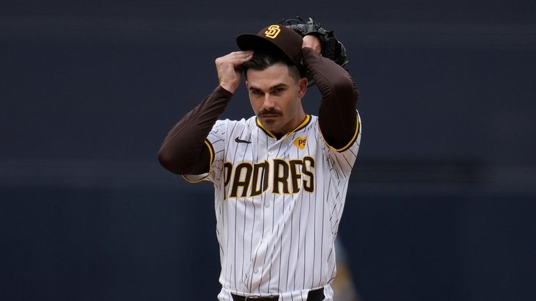 San Diego Padres starting pitcher Dylan Cease adjusts his hat...