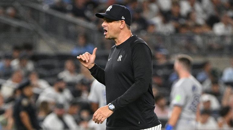 Yankees manager Aaron Boone walks to the dugout after a...