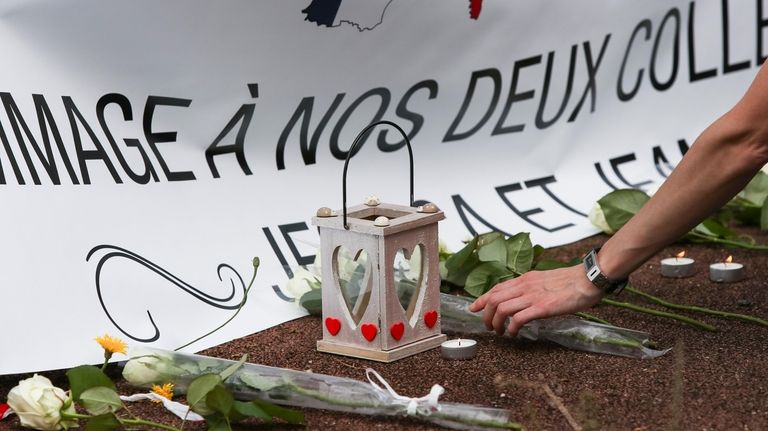 A person places flowers outside the home of the two...