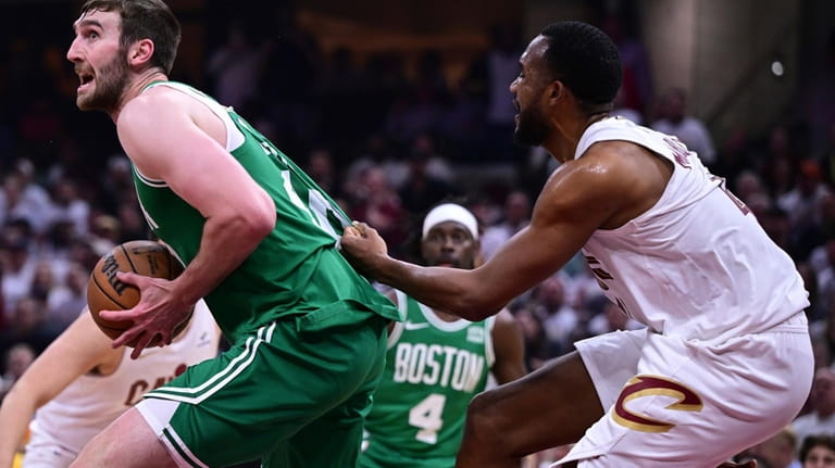 Boston Celtics center Luke Kornet, left, is grabbed by Cleveland...