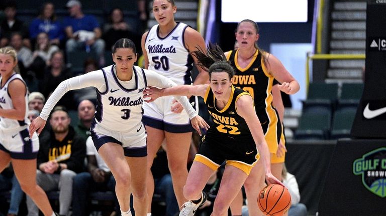 Caitlin Clark (22) fights for a loose ball over Kansas...