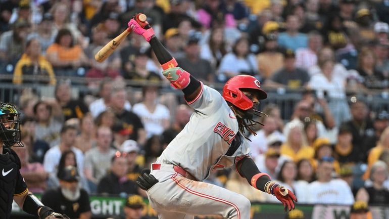 Cincinnati Reds' Elly De La Cruz, right, hits an RBI...