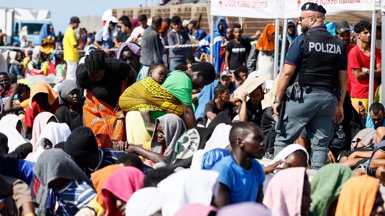 Migrants wait to be transferred from the Lampedusa Island to...