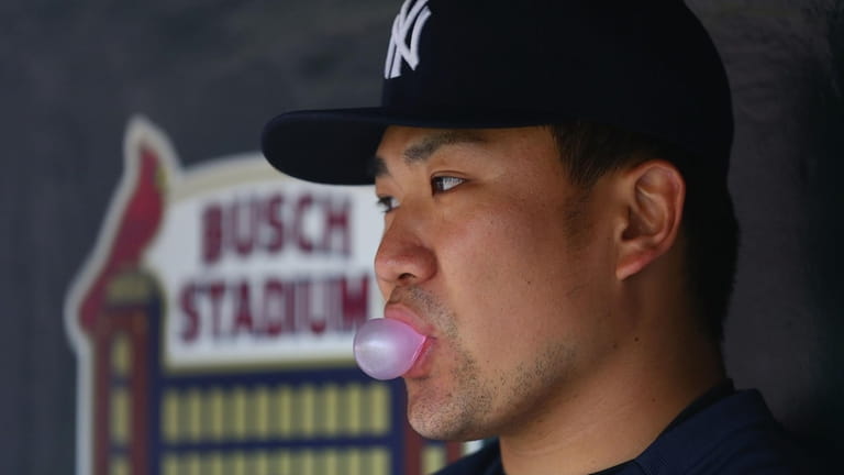 Masahiro Tanaka #19 of the Yankees looks on from the dugout...