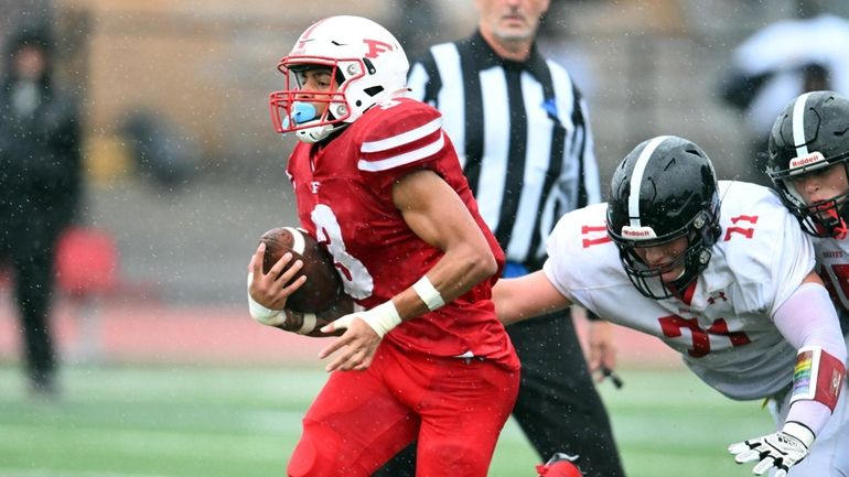 Freeport's D'Angelo Gordon breaks the tackle of Syosset's Sean Dillon as he...