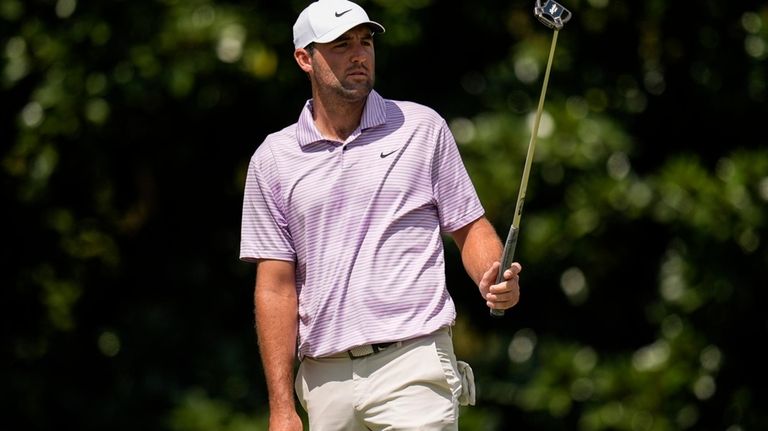 Scottie Scheffler watches his putt on the second green during...