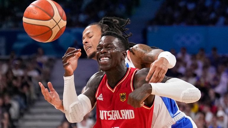 Dennis Schroder, of Germany, is hit as he drives past...