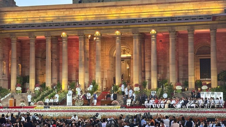 People watch as Narendra Modi takes oath as Prime Minister...