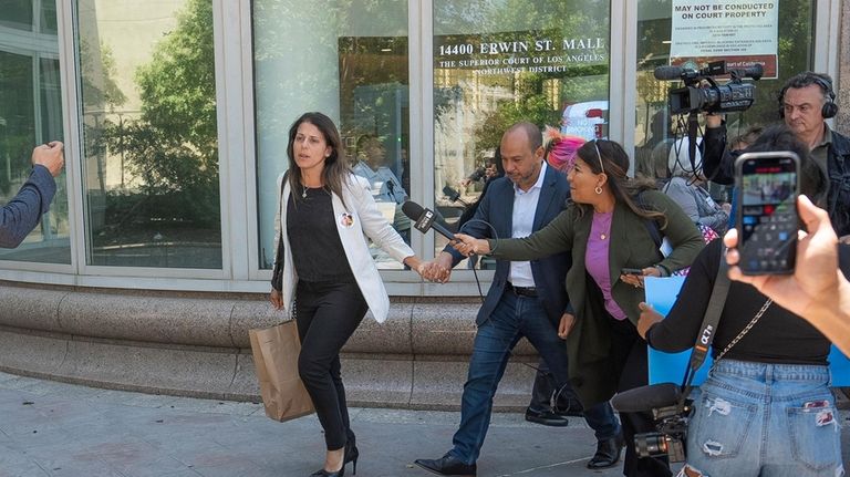 Nancy Iskander, left, holding the hand of her husband, Karim,...