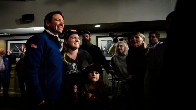 Republican presidential candidate Ron DeSantis poses for photos with people...