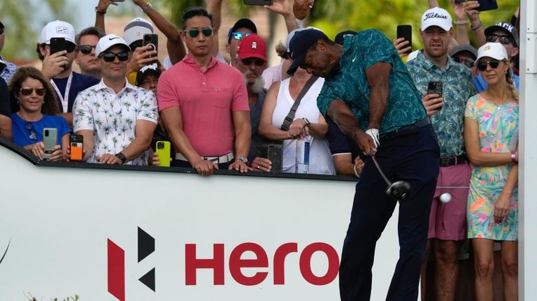 Tiger Woods tees off on the first hole during the...