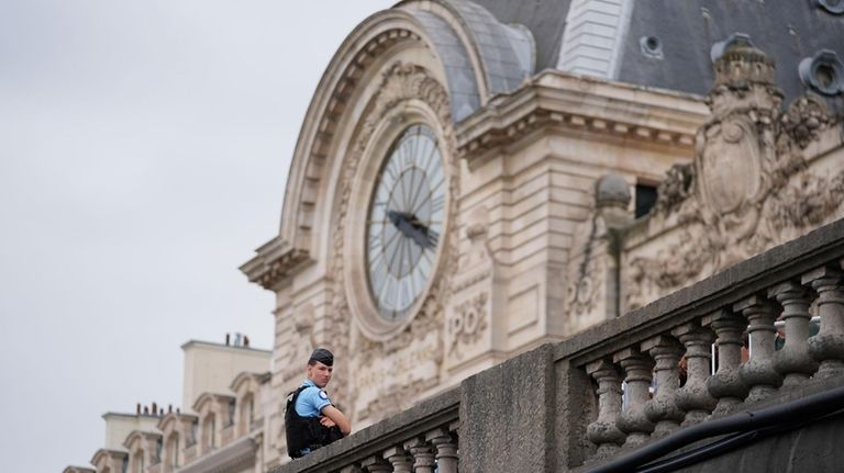 A police officer stands watch near the Musée d'Orsay as...