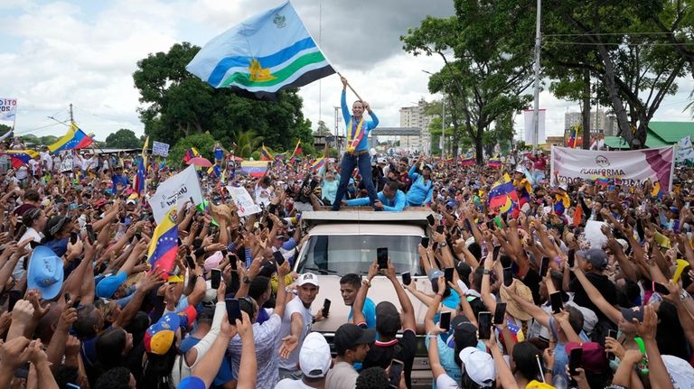 Opposition leader Maria Corina Machado waves a Monagas state flag...