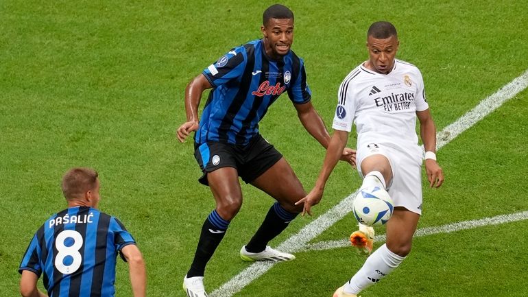 Real Madrid's Kylian Mbappe, right, controls the ball next to...