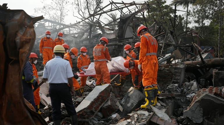 National Disaster Response Force rescuers carry the dead body of...