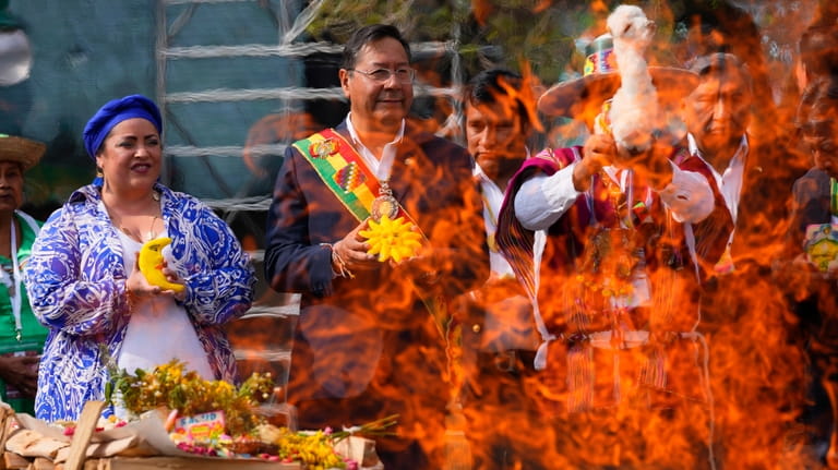 Bolivia's President Luis Arce, center, attends a ritual in honor...
