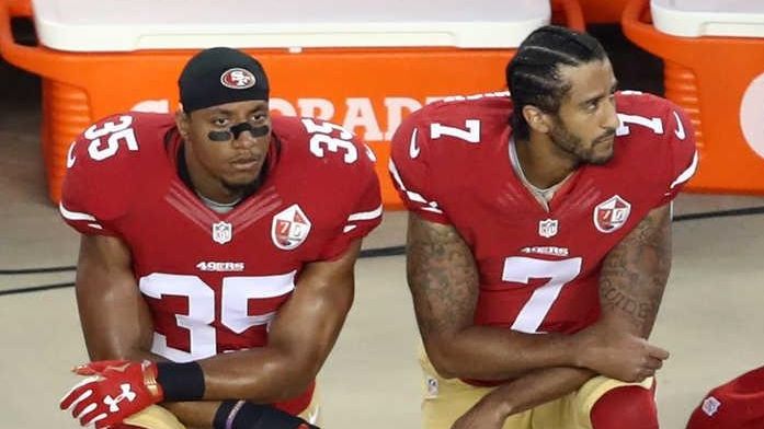 Colin Kaepernick, No. 7, and Eric Reid, No. 35, of...