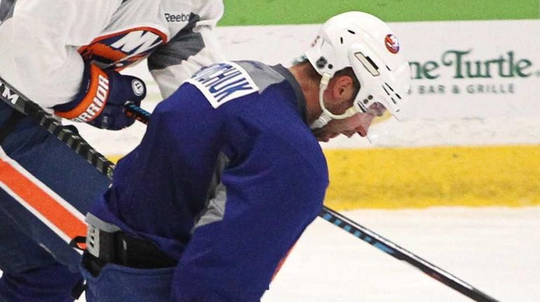 Andrew Ladd, left, and Johnny Boychuk, right, battle for the...